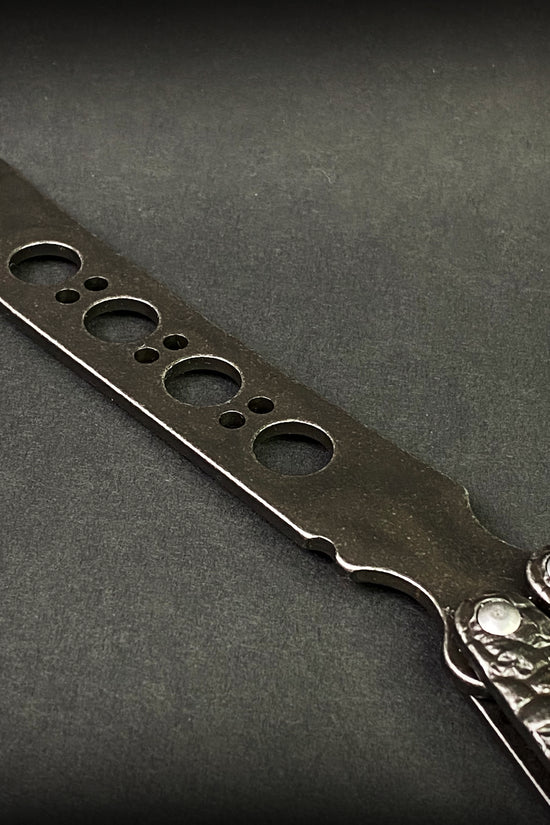 Close-up of skull-handle skeletonized knife blade