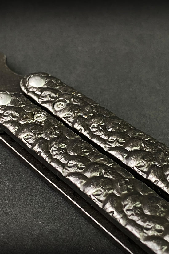 Skull-textured handle on dark hunting knife