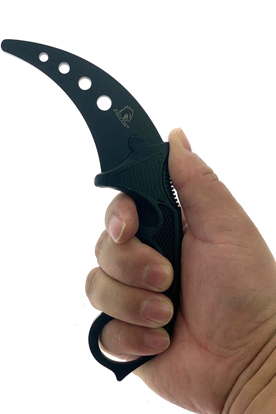Hand holding black karambit knife blade