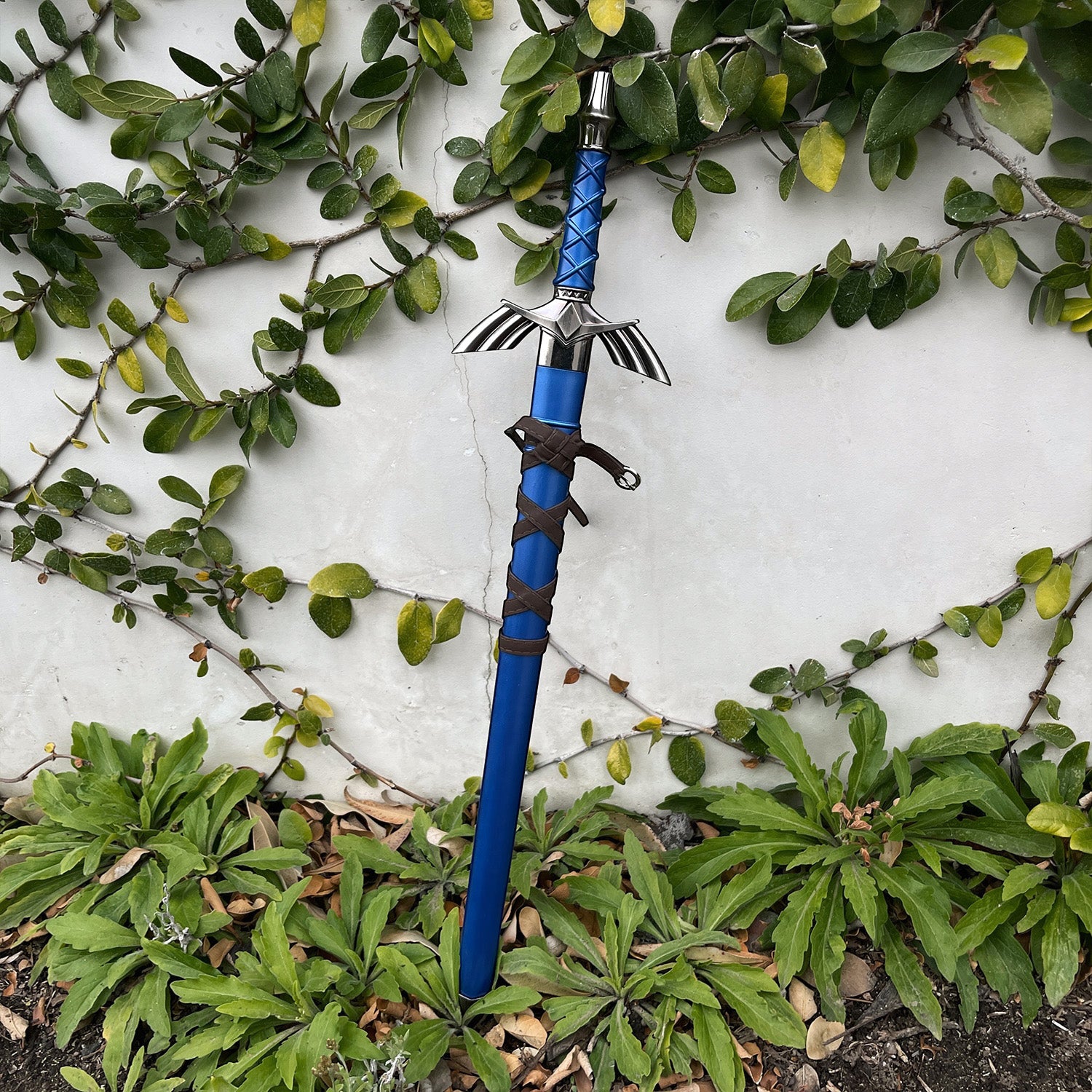Blue fantasy sword standing among garden plants