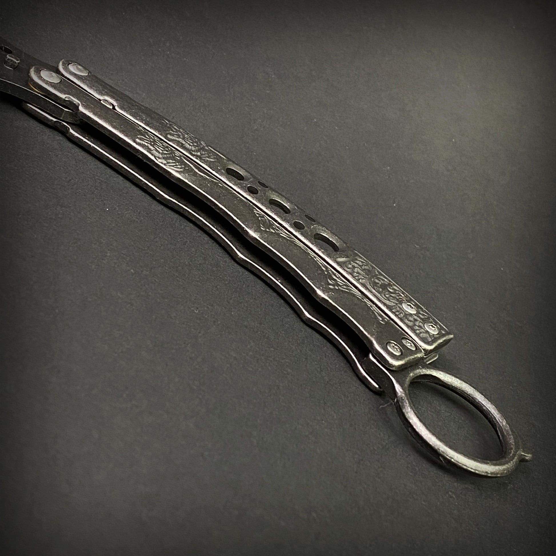 Guild Arms black butterfly trainer knife with detailed handle on dark background