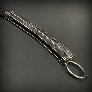 Guild Arms black butterfly trainer knife with detailed handle on dark background