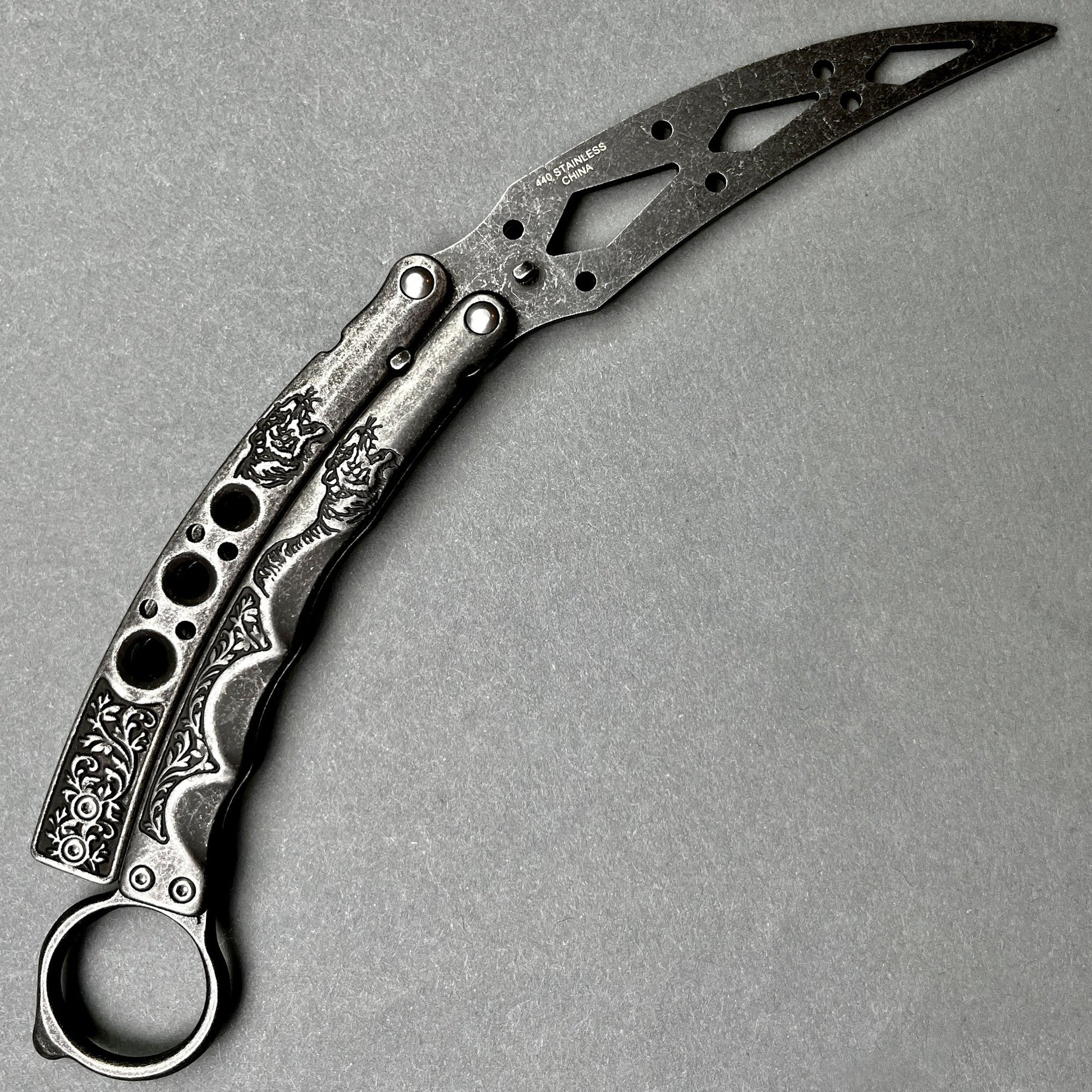 Guild Arms black butterfly trainer knife with ornate engraved handles and skeletonized blade