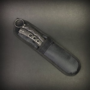 Guild Arms black butterfly trainer knife with textured handles in a black nylon sheath