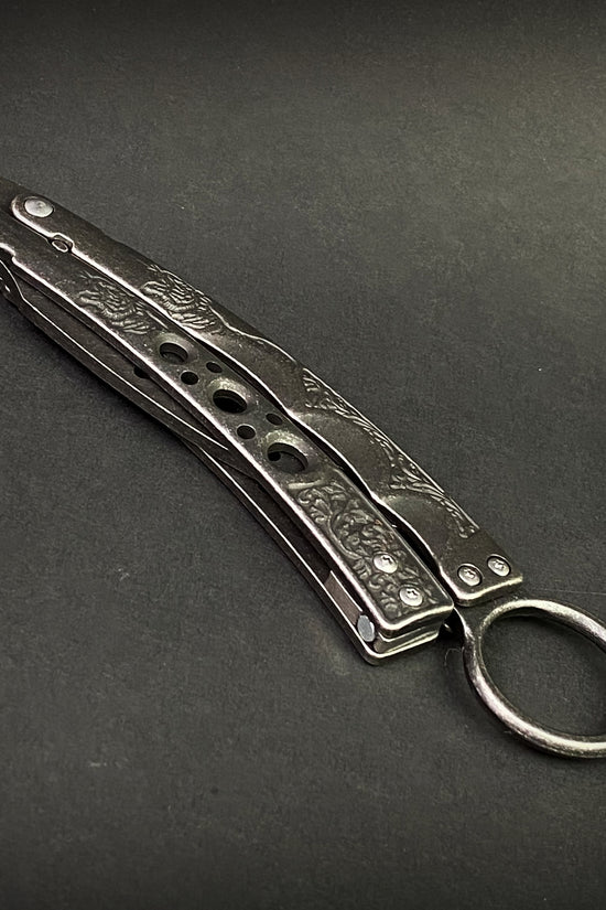 Guild Arms black butterfly trainer knife with engraved metal handles on black background