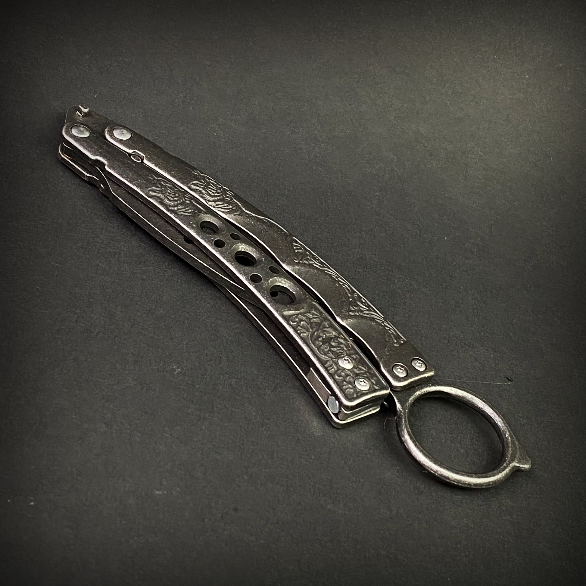 Guild Arms black butterfly trainer knife with engraved metal handles on black background