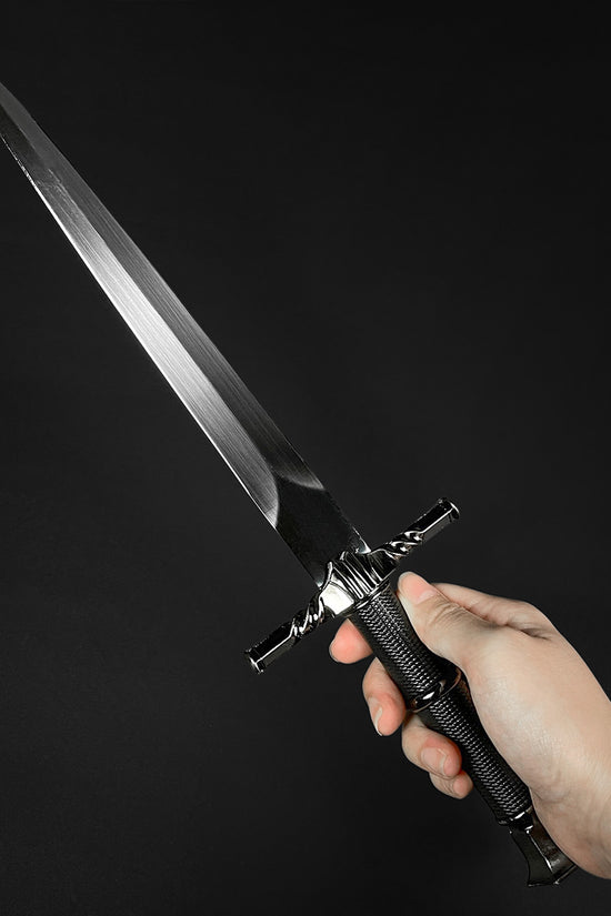 Hand holding a black medieval dagger w/Black Plastic Scabbard showcasing its sleek blade and detailed handle