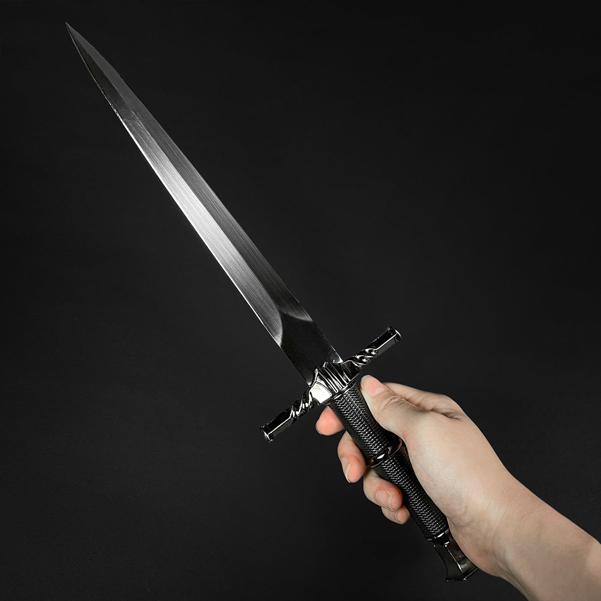 Hand holding a black medieval dagger w/Black Plastic Scabbard showcasing its sleek blade and detailed handle