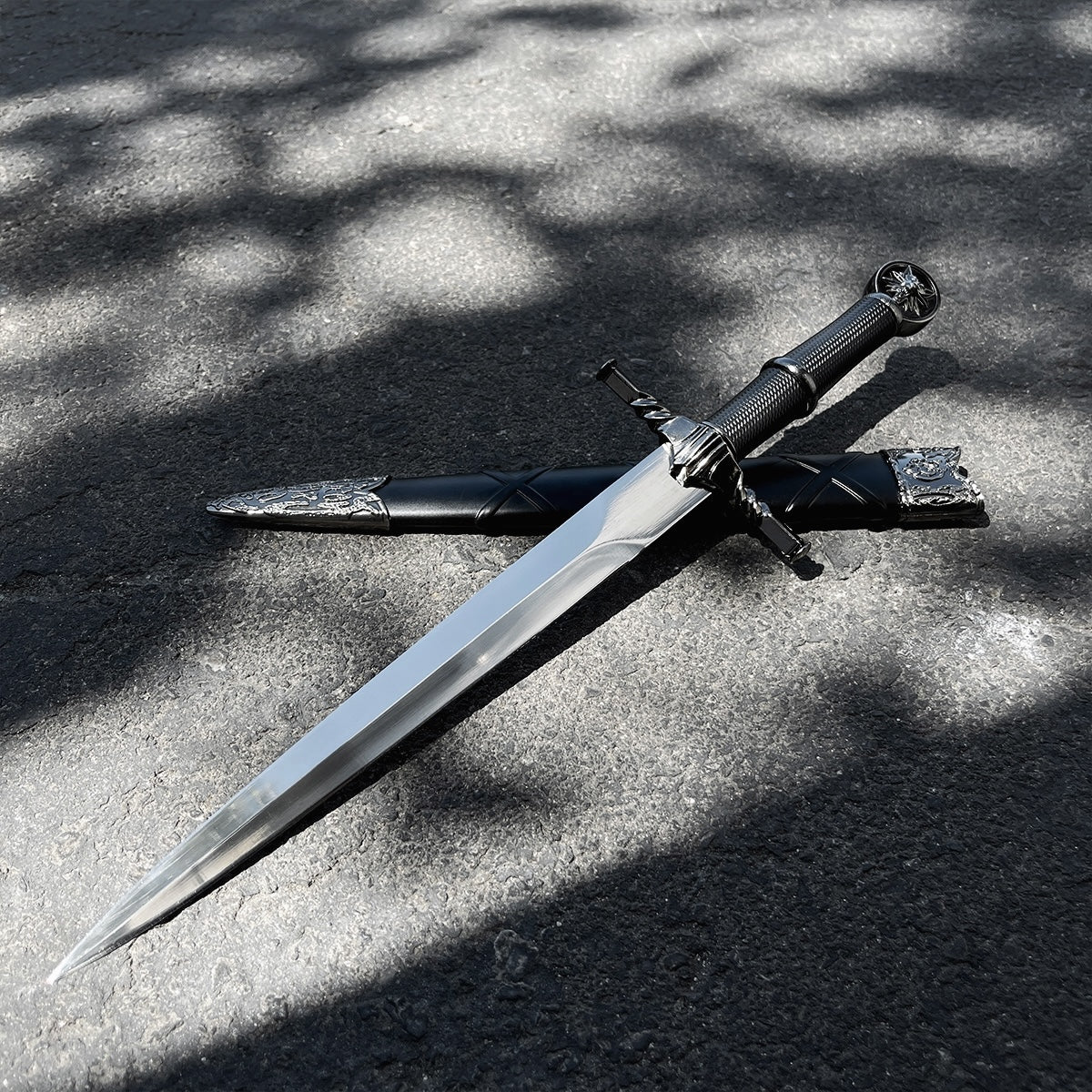 Black Wolf Head Medieval Dagger w/Plastic Scabbard displayed on a surface with sunlight casting shadows