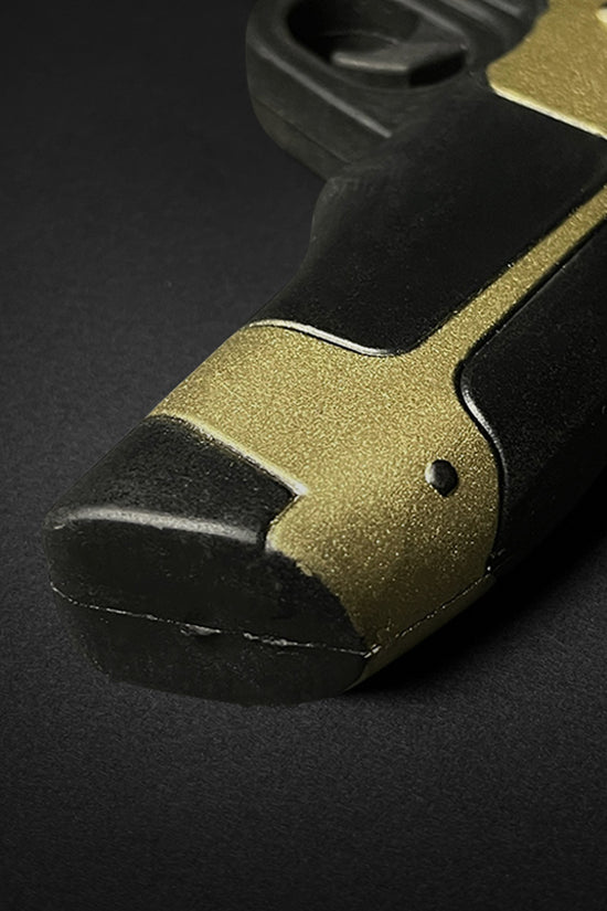 Close-up of Otaku Gear cosplay foam pistol gun handle with black and gold detail
