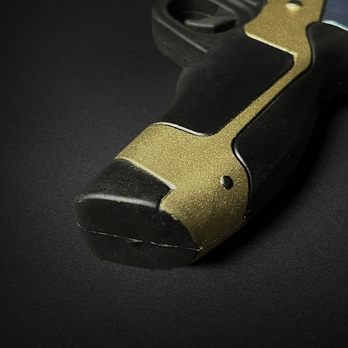 Close-up of Otaku Gear cosplay foam pistol gun handle with black and gold detail