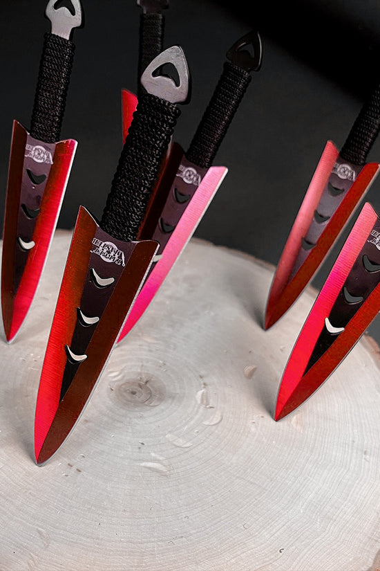 Falcon 6 PCS Red Throwing Knives Set arranged on a wooden surface showcasing their vibrant design
