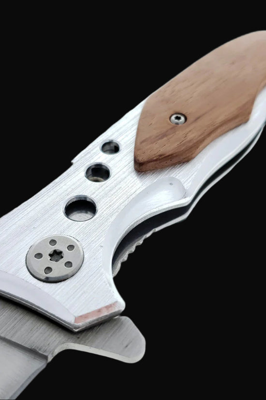 Close-up of Falcon EDC knife wood handle on spring assisted pocket knife with metal blade