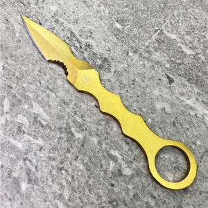 falcon tactical knife fixed blade gold anodized ring handle with ergonomic finger grooves on gray stone background