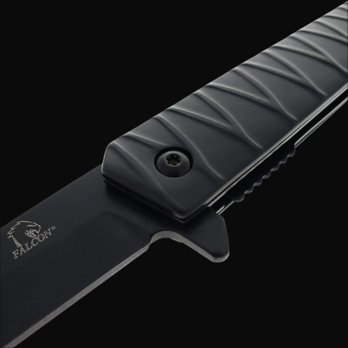 Close up view of Falcon tanto spring assisted pocket knife . black tanto blade and textured ridged handle with logo