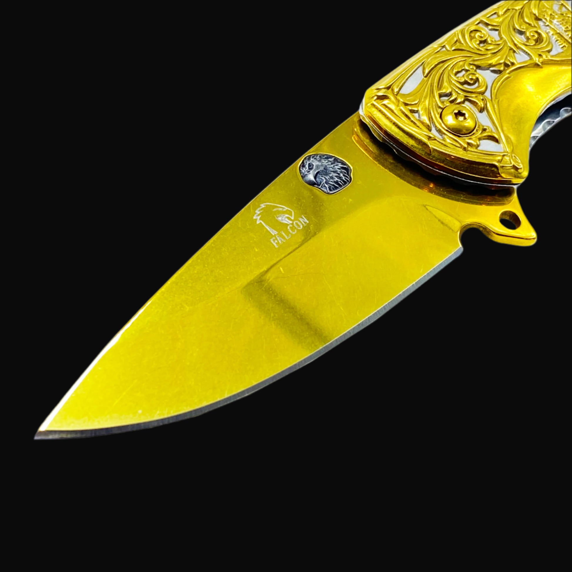 Falcon gold spring assisted knife with ornate engraved handle and sharp blade close-up