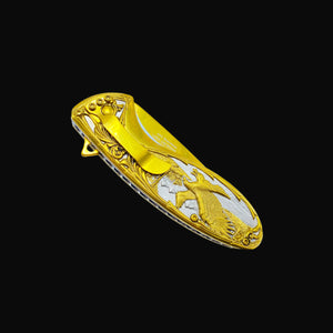 Falcon gold spring assisted knife with detailed eagle design and pocket clip on black background