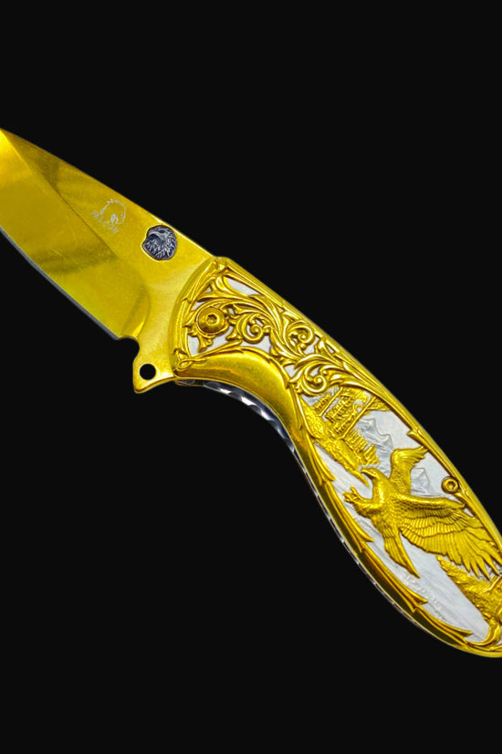Falcon gold spring assisted knife with ornate eagle design and detailed handle engraving