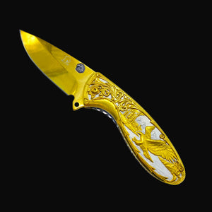 Falcon gold spring assisted knife with ornate eagle design and detailed handle engraving