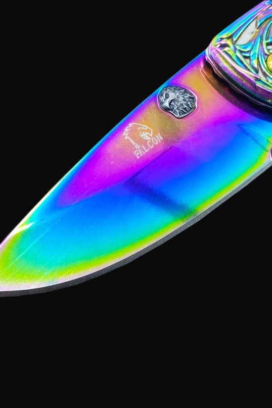 Close-up of Falcon Knives Rainbow Eagle and Ornate Spring Assisted Knife blade with vibrant rainbow finish and detailed handle