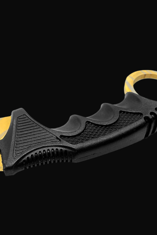 Black ergonomic handle of falcon trainer karambit knife with finger grooves and yellow blade