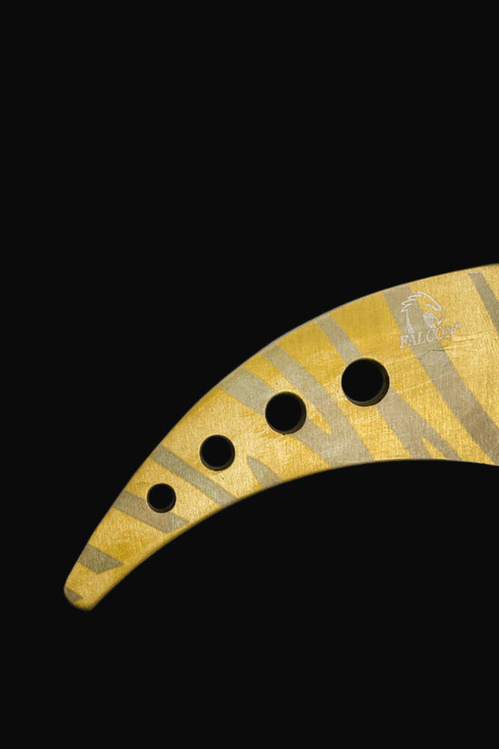 Gold and black Falcon trainer karambit knife with ergonomic handle and curved blade design