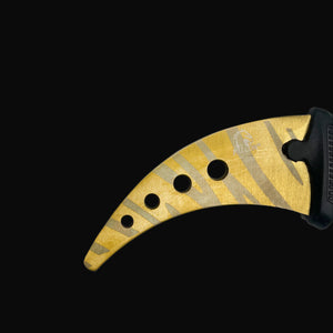 Gold and black Falcon trainer karambit knife with ergonomic handle and curved blade design
