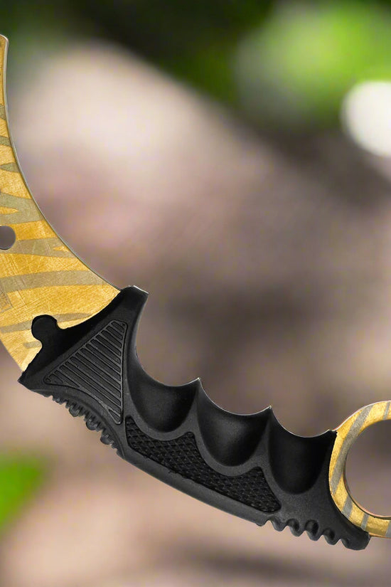 Falcon trainer karambit knife with curved gold blade and black ergonomic handle for safe practice