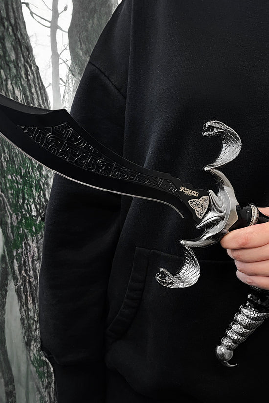 Fantasy Edge 12 Scorpion Dagger Curved Blade Scorpion Dagger W Stand held in hand against a dark forest backdrop