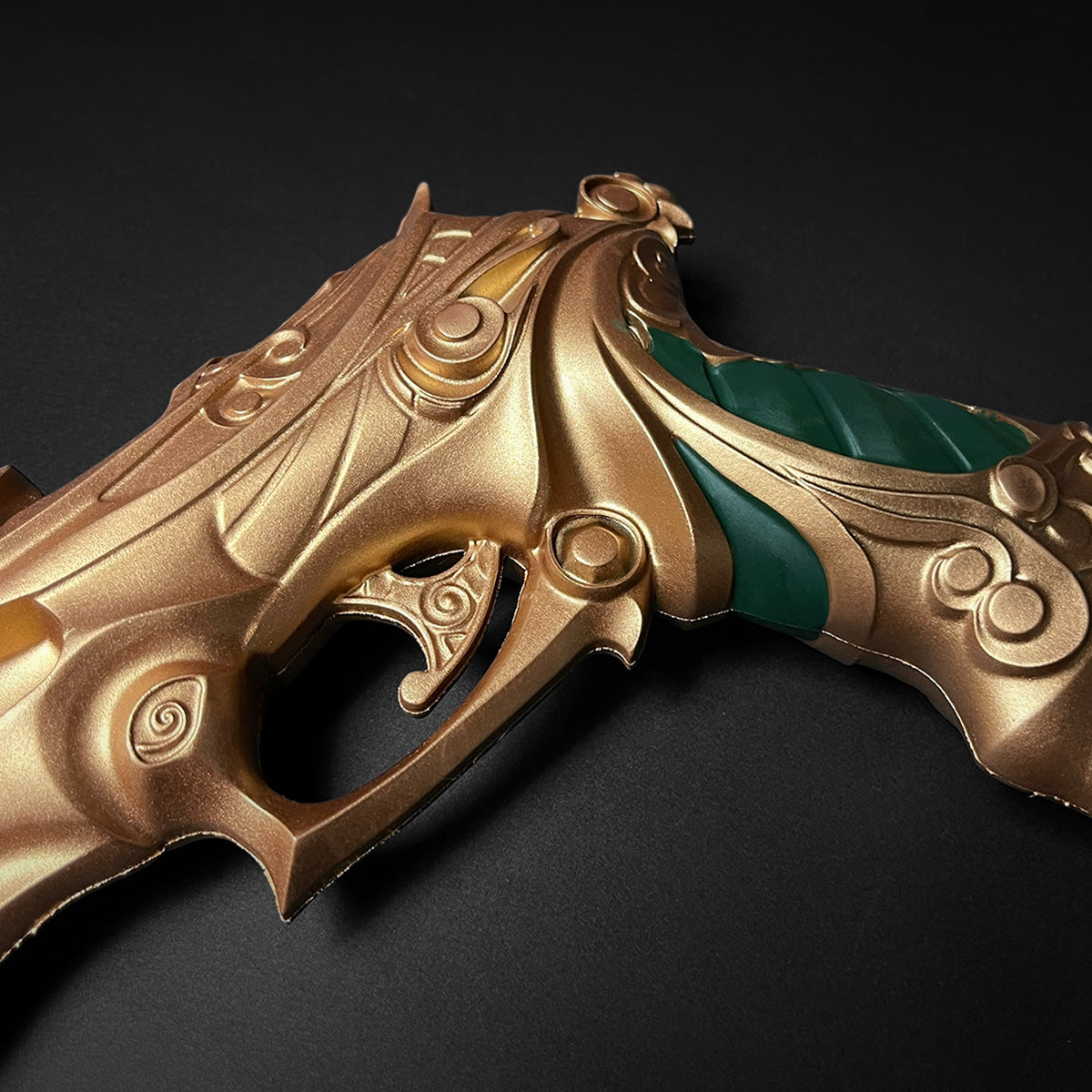 Otaku Gear ornate gold and green foam fantasy gun prop close up showing carved details and ergonomic grip