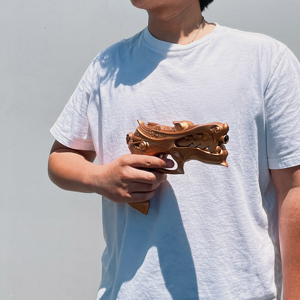 Otaku Gear foam fantasy gun prop gold dragon design held by person in white t shirt