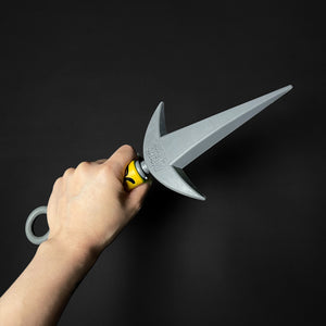 Hand holding Otaku Gears foam flying thunder kunai foam dagger with pointed gray blade and yellow handle
