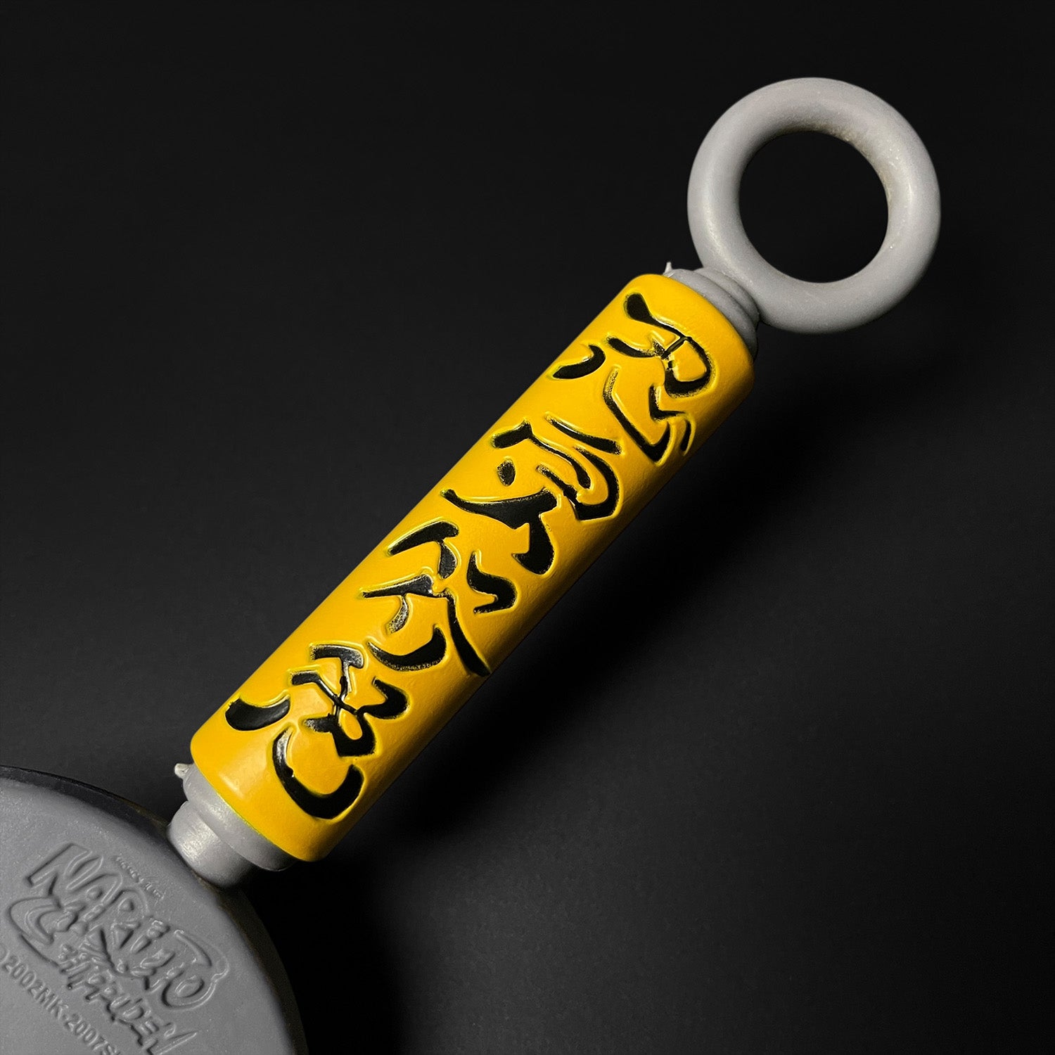 Otaku Gears foam flying thunder kunai with yellow handle and black Japanese characters on a black background