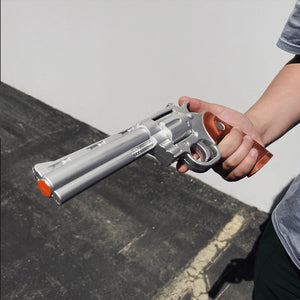 Guild Arms anime foam gun silver revolver with wooden grip and orange tips held by person foam revolver prop for cosplay