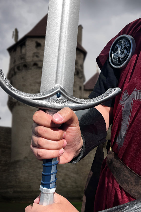 Guild Arms foam Ring Medieval sword held by a person in a tunic near a castle backdrop