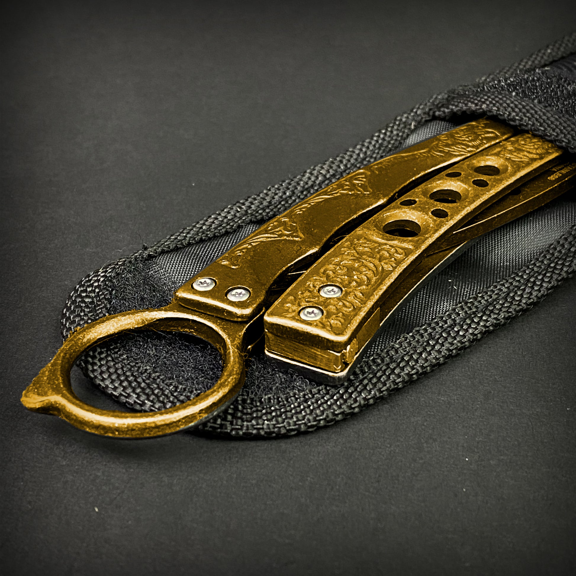 Guild Arms gold butterfly trainer knife with detailed textured handles on black fabric sheath