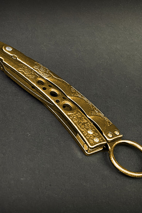 Gold butterfly trainer knife by Guild Arms with engraved handle and ring for practice
