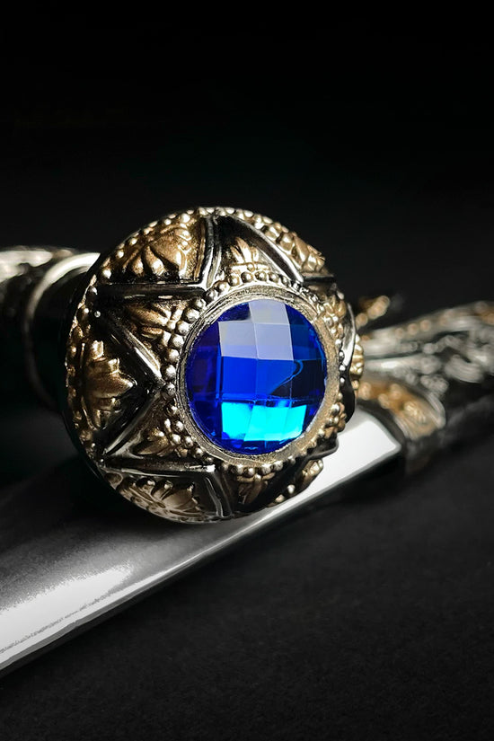 Fantasy Edge Roman dagger with blue crystal ornate brass pommel and polished steel blade close up