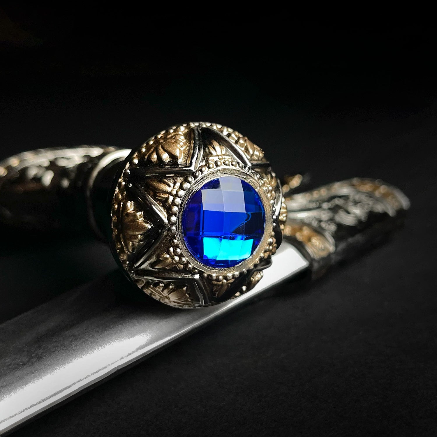 Fantasy Edge Roman dagger with blue crystal ornate brass pommel and polished steel blade close up