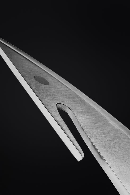 Close-up of a large hunting knife blade by Guild Arms with a sharp tip and sleek design