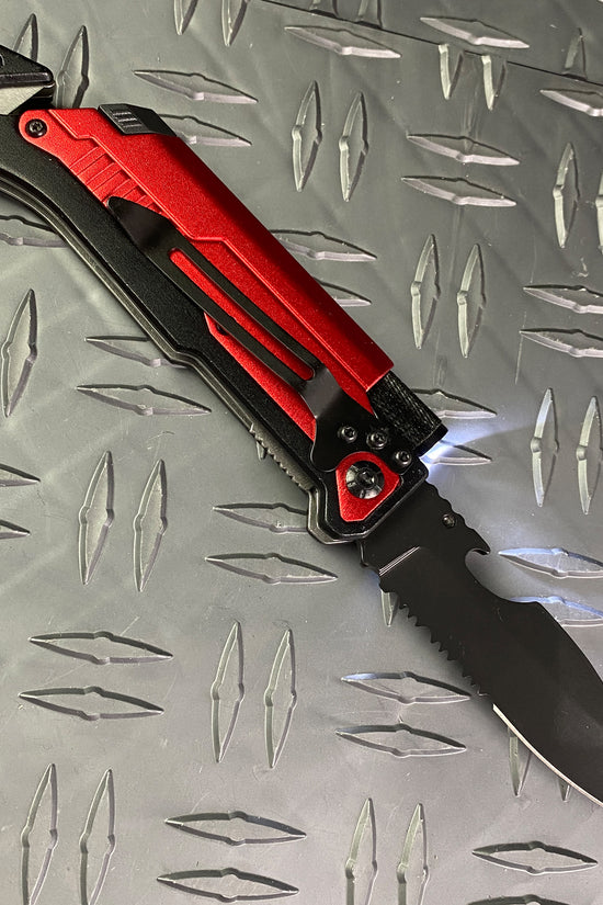Multi-Tool - Falcon Spring Assisted Knife Red Handle w/ Firestarter & Flashlight on metal surface