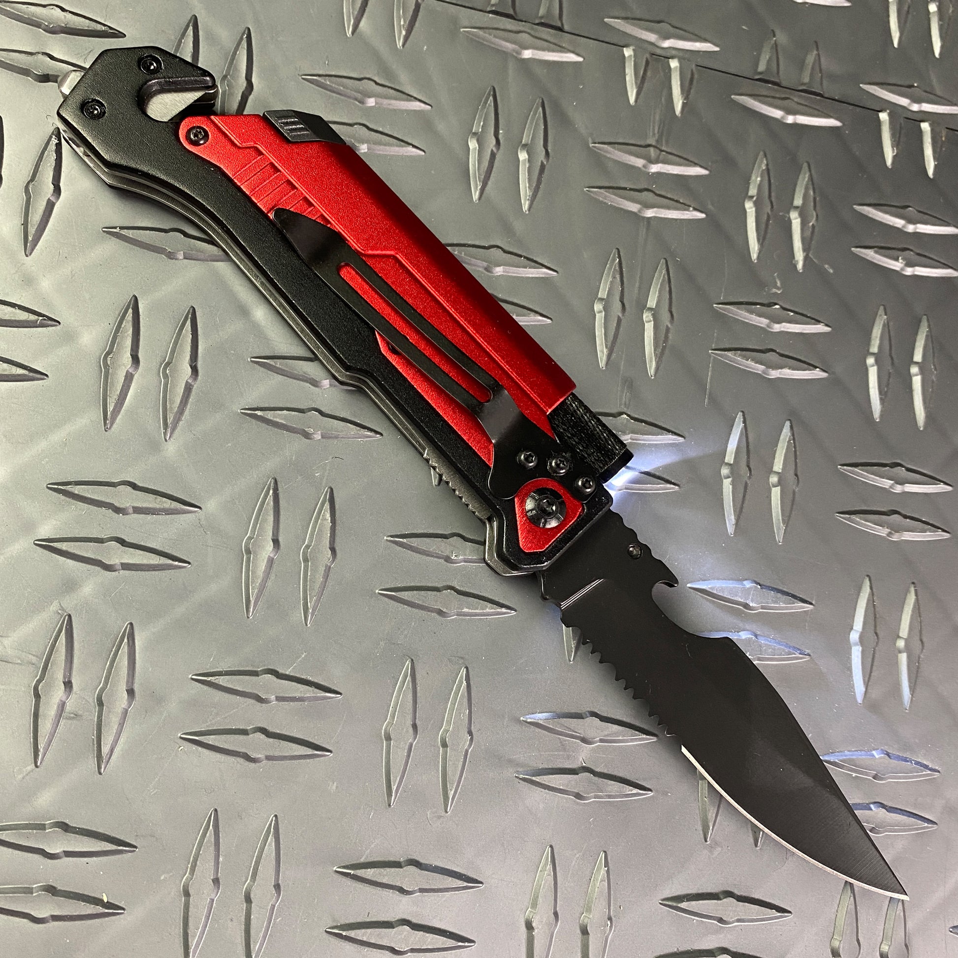 Multi-Tool - Falcon Spring Assisted Knife Red Handle w/ Firestarter & Flashlight on metal surface