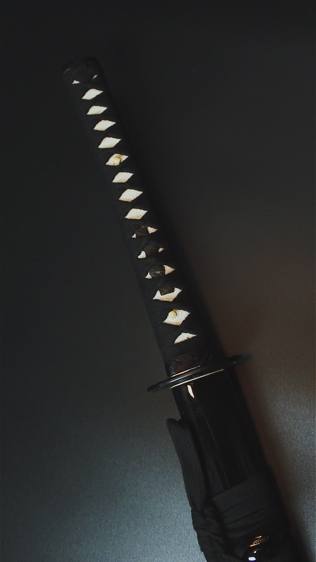 A close-up of a katana hilt - Guild Arms.