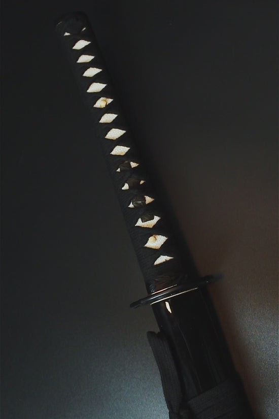 A close-up of a katana hilt - Guild Arms.