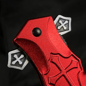 Close-up of red cross handle spring pocket knife by Guild Arms with unique design and metallic finish