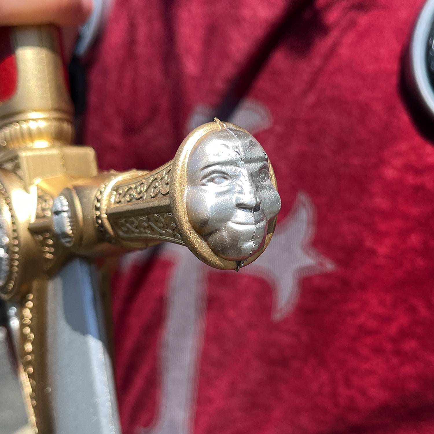 Close-up of the hilt detailing on a red freemason Foam sword by Guild Arms