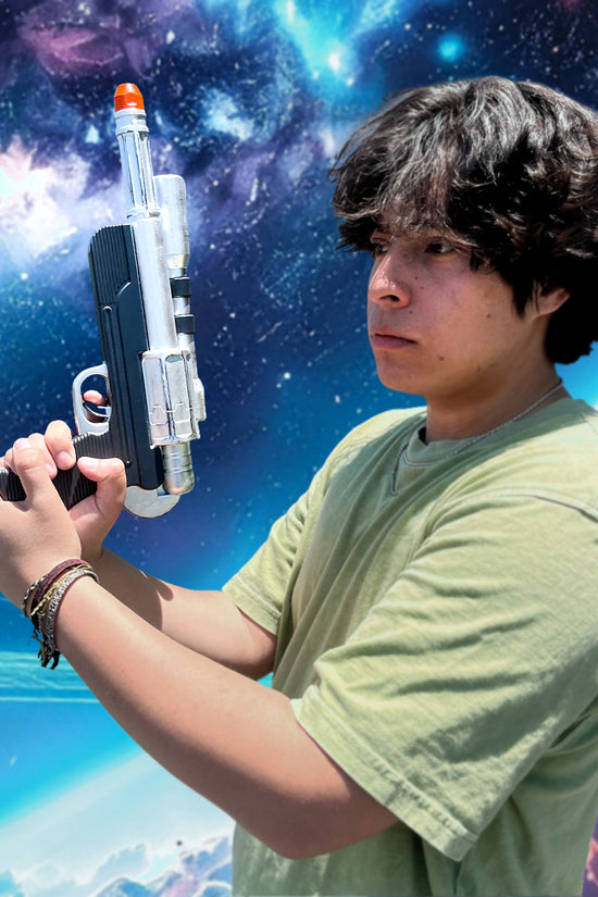 Otaku Gear Sci-fi foam laser gun for Cosplay held by a person against a vibrant cosmic background