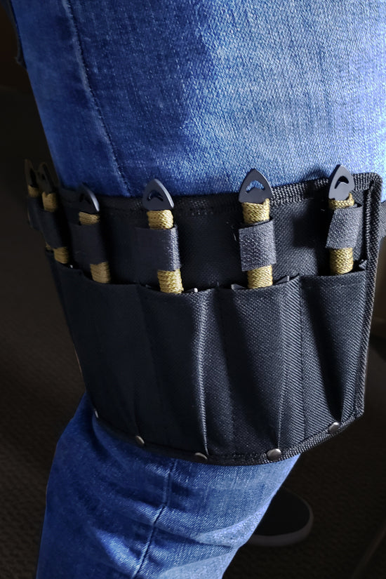 Target Master leg sheath with Falcon 6 PC throwing knives set strapped to thigh over blue jeans