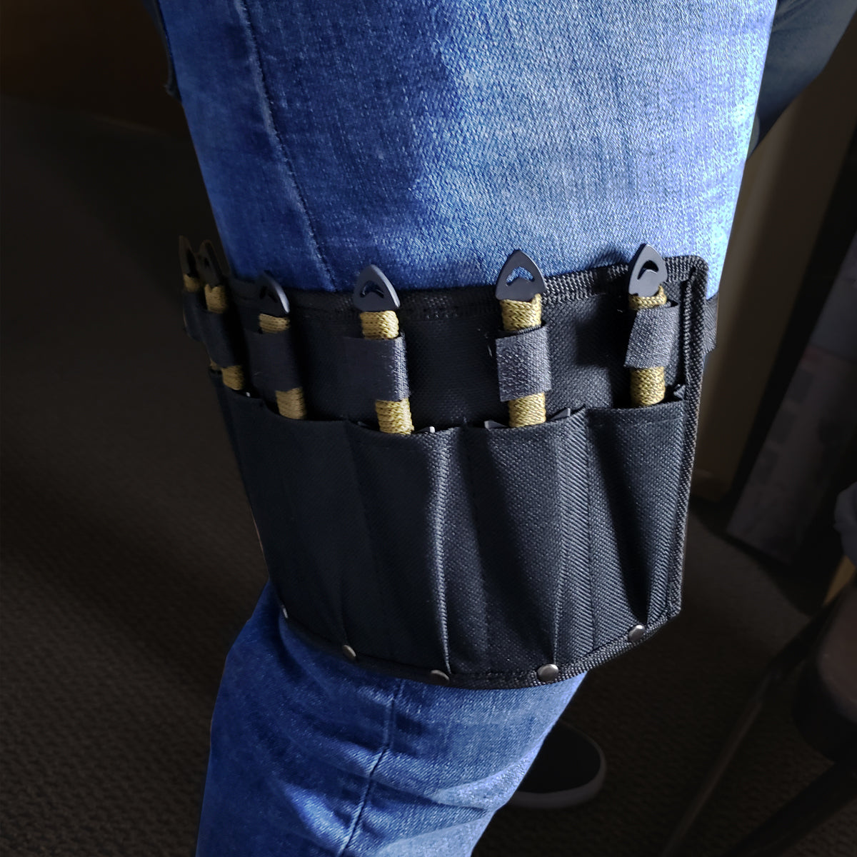 Target Master leg sheath with Falcon 6 PC throwing knives set strapped to thigh over blue jeans