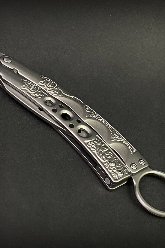 Guild Arms butterfly knife trainer for beginners with engraved silver metal handle on black background